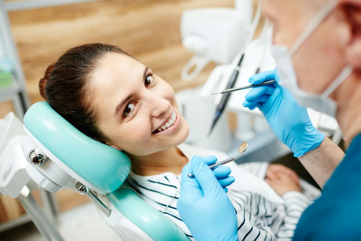smiling woman receiving dental procedure from dentist