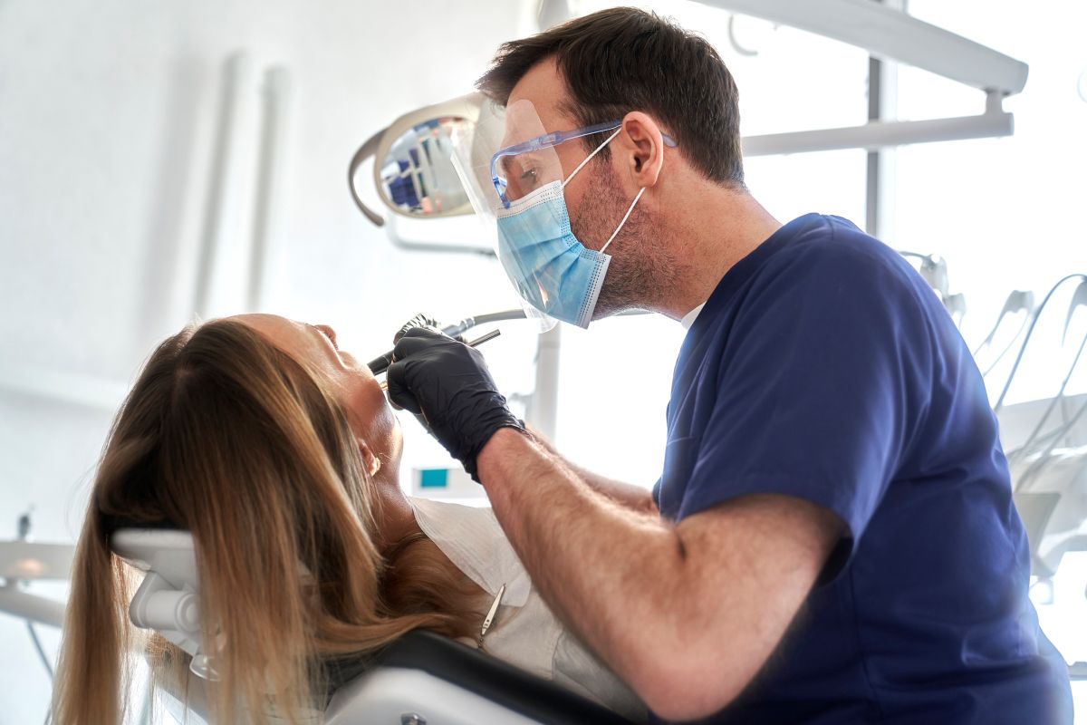 dentist examining a female patient's teeth in a modern dental office