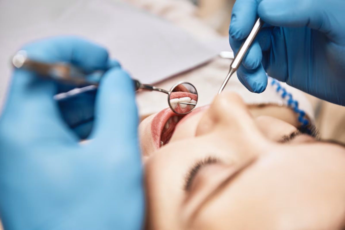 close-up view of a dental check-up, showing a dentist using instruments to inspect a woman's teeth
