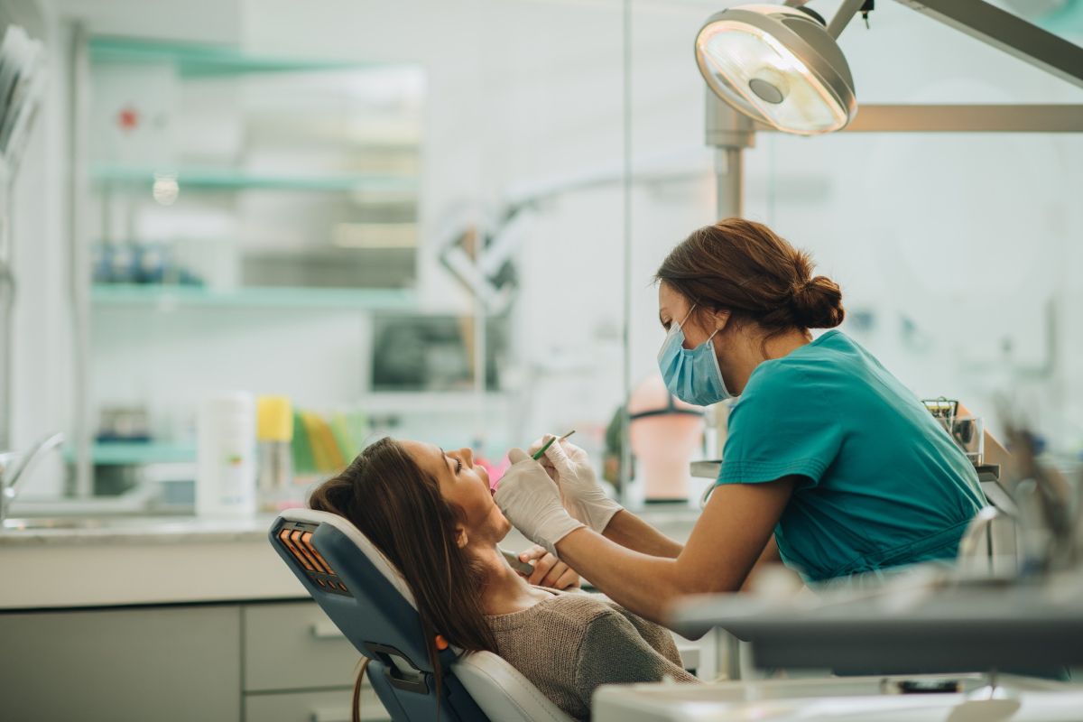 female dentist performing a dental check-up on a patient in a clinic
