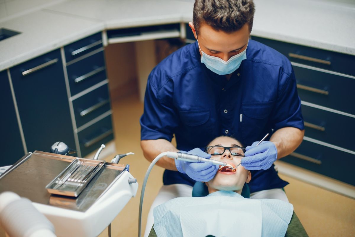 a dentist examining a patient's teeth in a dental clinic