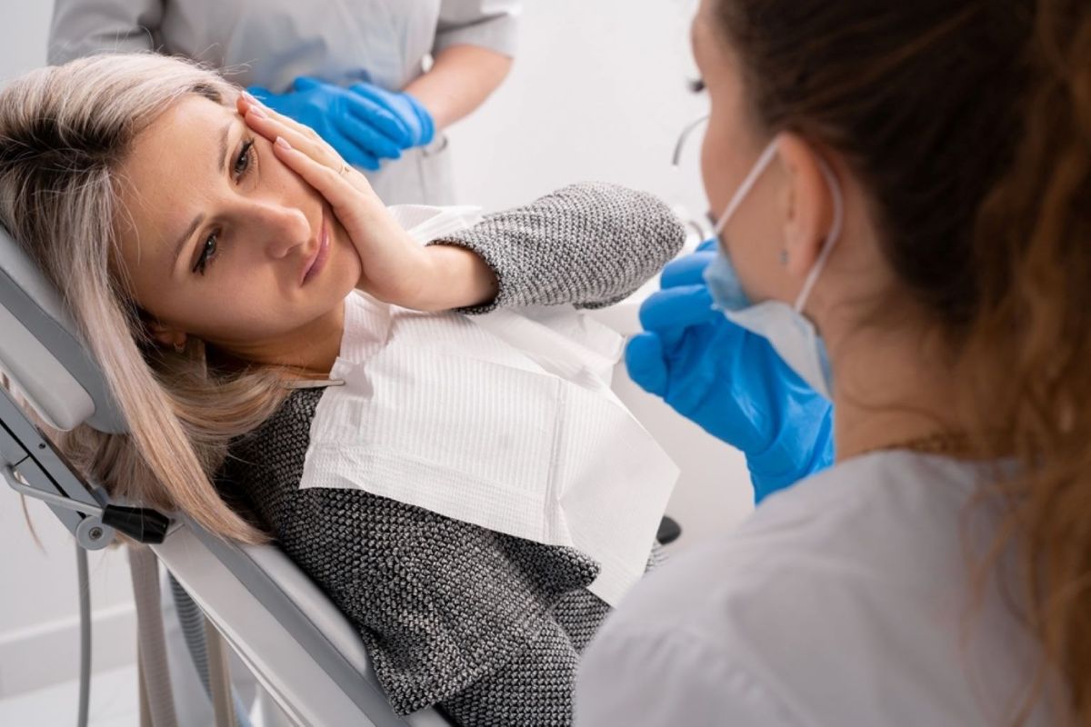 female patient discussing dental pain with dentist during dental checkup