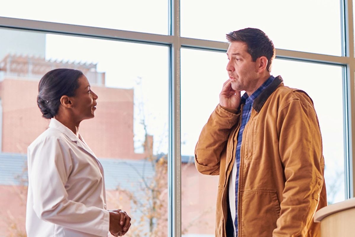 patient and dentist talking about dental care and oral hygiene in office